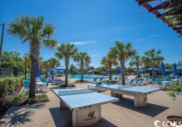 surrounding community featuring a pool, fence, and a patio area
