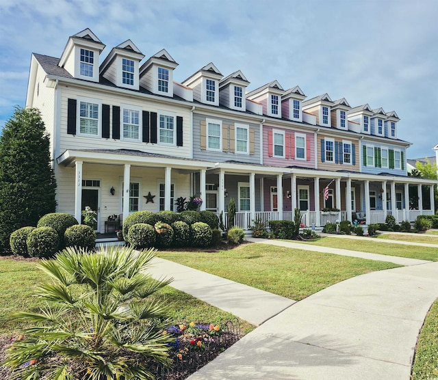 townhome / multi-family property featuring covered porch and a front yard