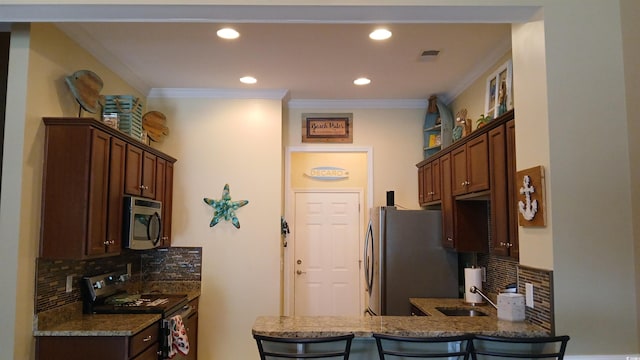 kitchen with stainless steel appliances, tasteful backsplash, dark stone counters, crown molding, and a peninsula