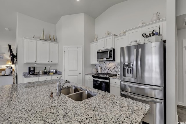 528 Courtridge Loop, Conway, SC 29526 - kitchen featuring stainless steel appliances, a sink, vaulted ceiling, white cabinetry, and light stone counters