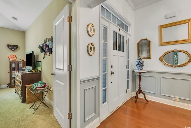entrance foyer with baseboards, crown molding, and wood finished floors