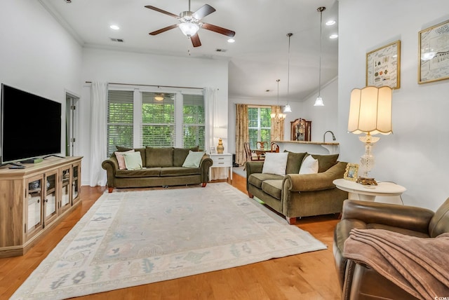 living area featuring ceiling fan, ornamental molding, and wood finished floors