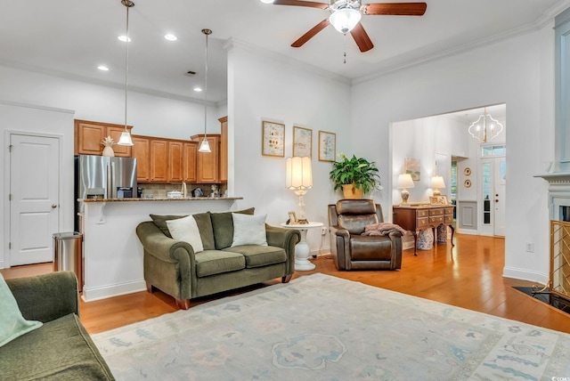 living room featuring light wood-style flooring, a ceiling fan, recessed lighting, crown molding, and a chandelier