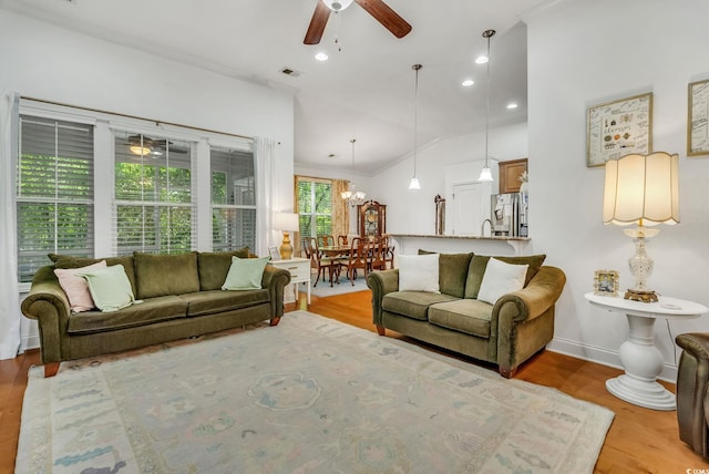 living area with a ceiling fan, wood finished floors, vaulted ceiling, a chandelier, and recessed lighting