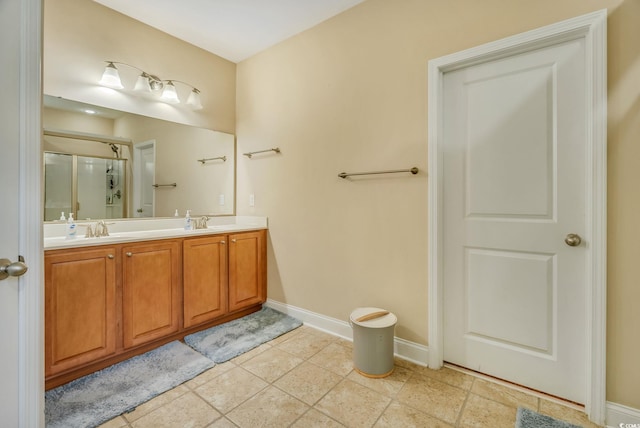 full bath featuring an enclosed shower, baseboards, and double vanity