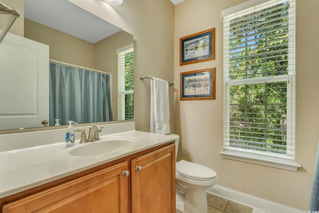 bathroom featuring tile patterned flooring, toilet, vanity, baseboards, and curtained shower