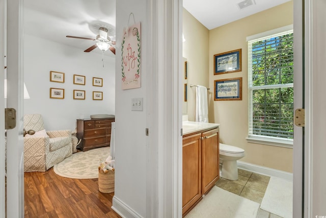 bathroom featuring ceiling fan, vanity, toilet, and baseboards