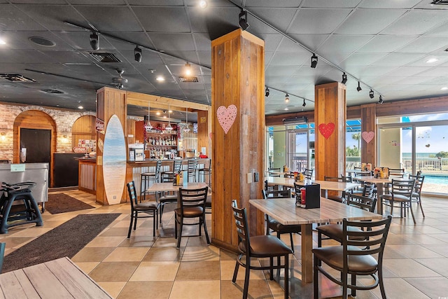 5300 N Ocean Blvd Unit 518, Myrtle Beach, SC 29577 - dining area featuring track lighting, light tile patterned floors, wooden walls, and a dry bar