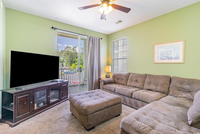 living area with a ceiling fan and light carpet
