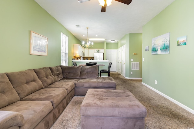 carpeted living area with a chandelier, a ceiling fan, and baseboards