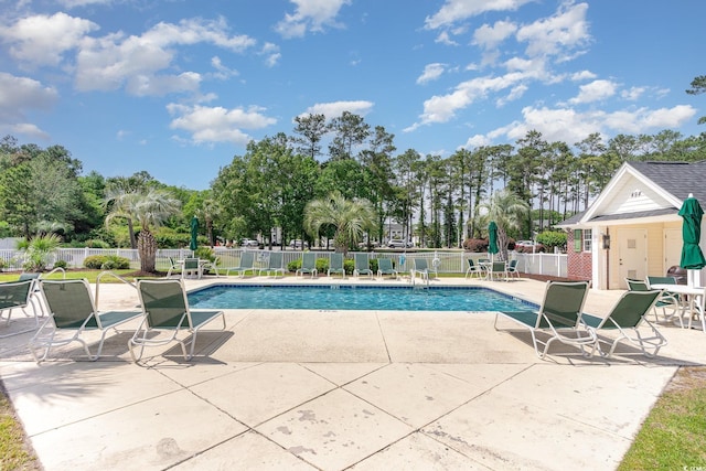 community pool with fence and a patio