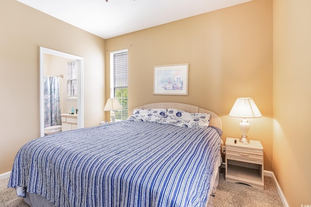 carpeted bedroom featuring baseboards and ensuite bathroom
