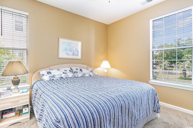 bedroom featuring carpet floors, multiple windows, and baseboards