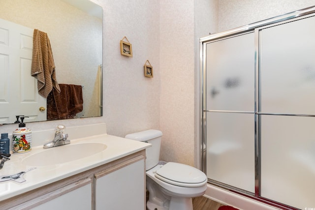 full bathroom with a shower stall, toilet, vanity, and wood finished floors