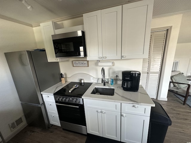 207 E Bobby Gerald Pkwy, Marion, SC 29571 - kitchen with range with electric cooktop, a sink, dark wood-style flooring, white cabinetry, and light stone counters
