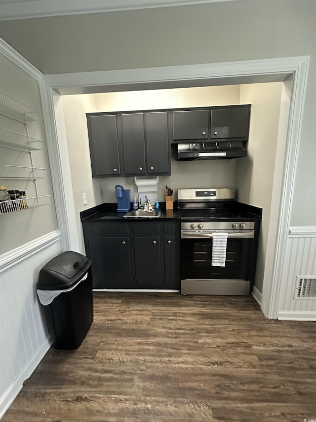 207 E Bobby Gerald Pkwy, Marion, SC 29571 - kitchen with electric range, under cabinet range hood, dark countertops, and dark wood-style flooring