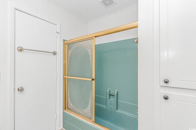 bathroom featuring ornamental molding, a textured ceiling, and a shower