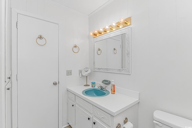 half bath featuring crown molding, toilet, and vanity