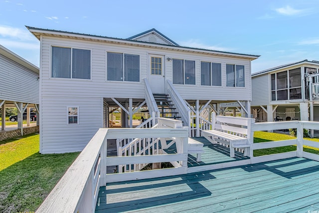 back of house with stairway, a wooden deck, a lawn, and metal roof