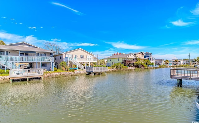 dock with stairs, a residential view, and a water view