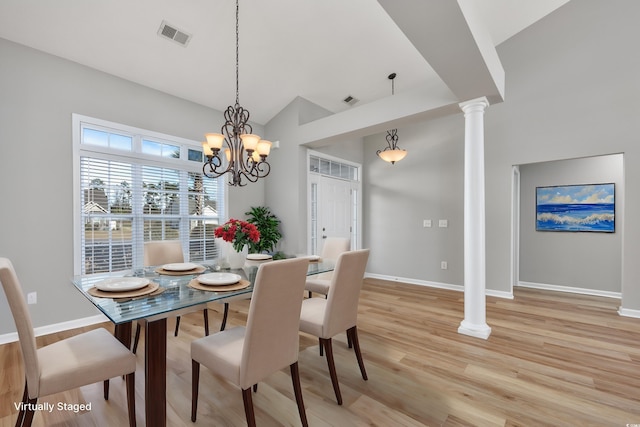 229 Duchess Ct, Myrtle Beach, SC 29588 - dining room featuring baseboards, light wood-type flooring, decorative columns, a chandelier, and high vaulted ceiling