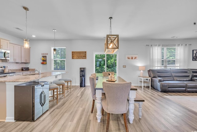 dining area featuring light wood-type flooring, baseboards, and recessed lighting