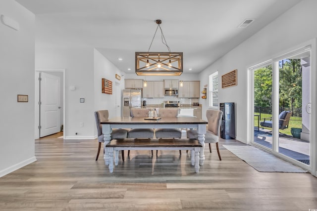 dining area with light wood-type flooring, recessed lighting, and baseboards