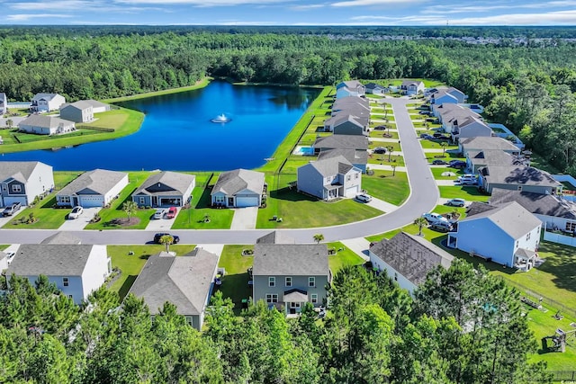aerial perspective of suburban area with a heavily wooded area and a nearby body of water