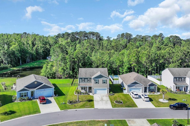 aerial view of residential area with a nearby body of water and a heavily wooded area