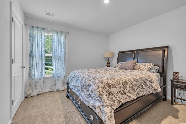 bedroom with light colored carpet and baseboards