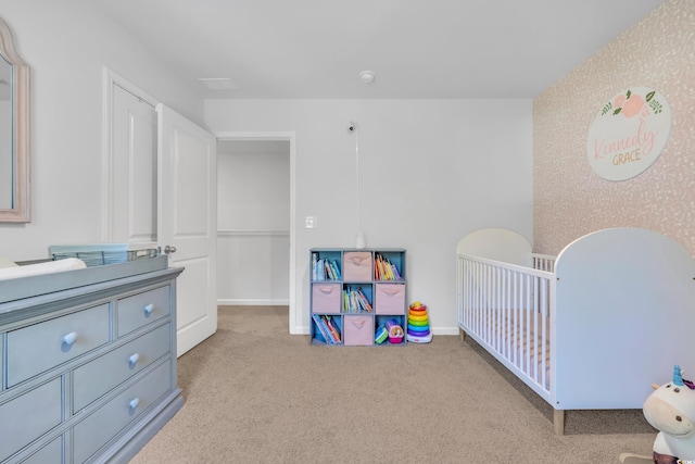 carpeted bedroom with a nursery area