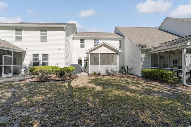 rear view of property featuring a sunroom and a yard