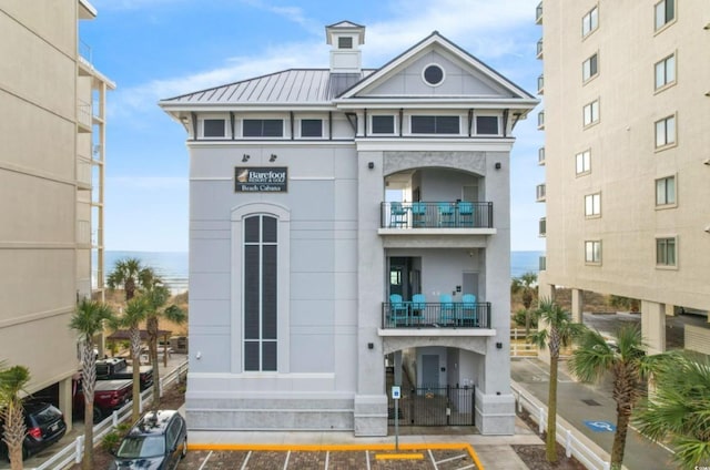 view of property with uncovered parking and a water view