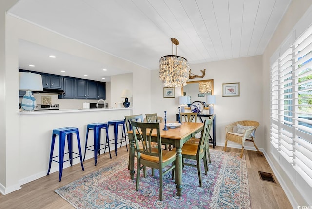 dining space with light wood finished floors, a chandelier, recessed lighting, and baseboards