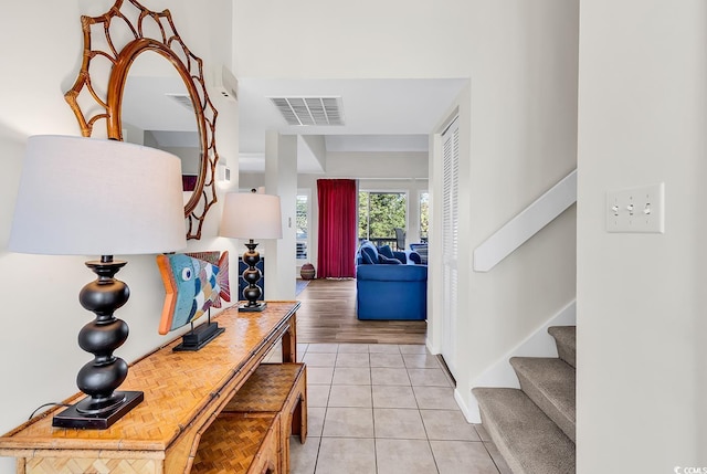 foyer entrance with stairway and light tile patterned flooring