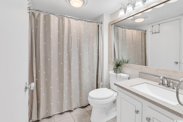 bathroom featuring tile patterned flooring, toilet, and vanity