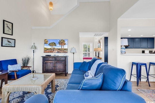 living area featuring light wood-style flooring, high vaulted ceiling, crown molding, and baseboards