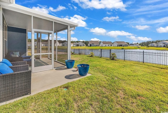 view of yard featuring a residential view, a patio area, a water view, and a sunroom