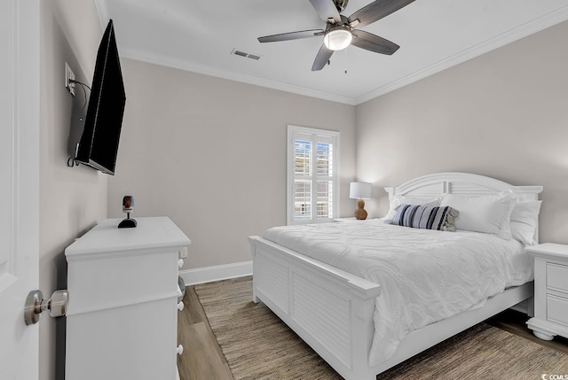 bedroom featuring wood finished floors, baseboards, crown molding, and a ceiling fan