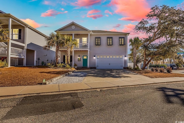 view of front of property featuring a balcony, a garage, and driveway