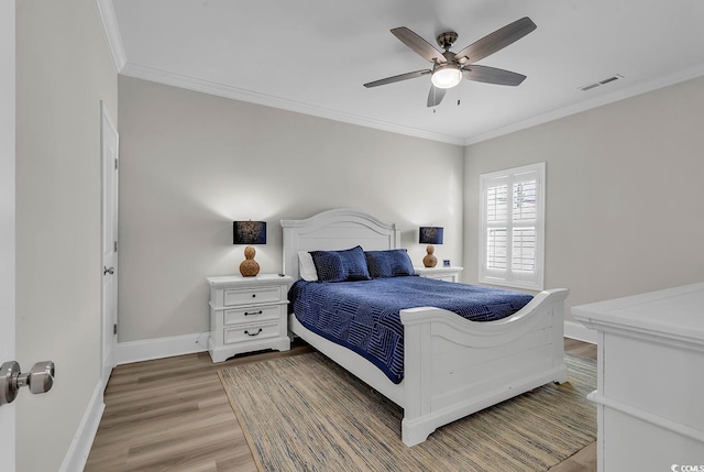 bedroom featuring light wood-style flooring, ornamental molding, baseboards, and a ceiling fan