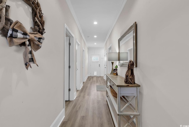 hallway with ornamental molding, recessed lighting, light wood-style flooring, and baseboards