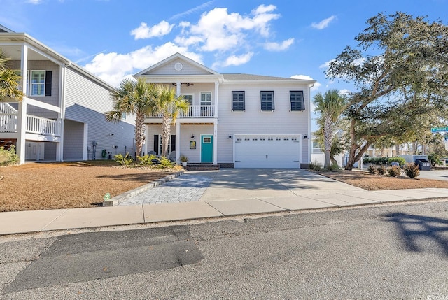 greek revival inspired property featuring an attached garage, driveway, and a balcony