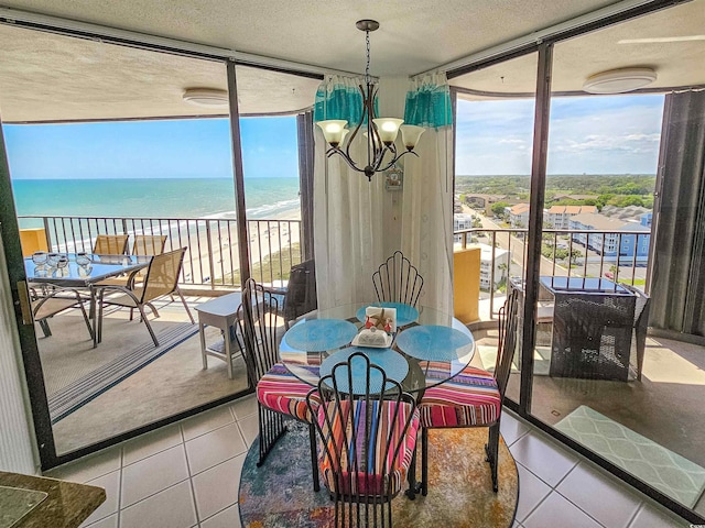 9650 Shore Dr Unit 1203, Myrtle Beach, SC 29572 - tiled dining room with a textured ceiling, a wall of windows, view of water and beach, and a chandelier