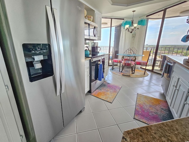 9650 Shore Dr Unit 1203, Myrtle Beach, SC 29572 - kitchen featuring stainless steel appliances, a chandelier, light tile patterned floors, and white cabinets