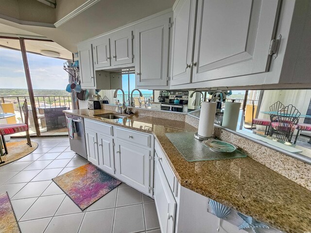 9650 Shore Dr Unit 1203, Myrtle Beach, SC 29572 - kitchen featuring a sink, dishwasher, white cabinets, light tile patterned floors, and expansive windows