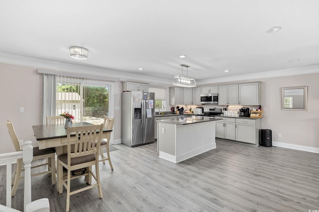 1720 Horry St, Conway, SC 29526 - kitchen with appliances with stainless steel finishes, a sink, ornamental molding, a kitchen island, and light wood-style floors