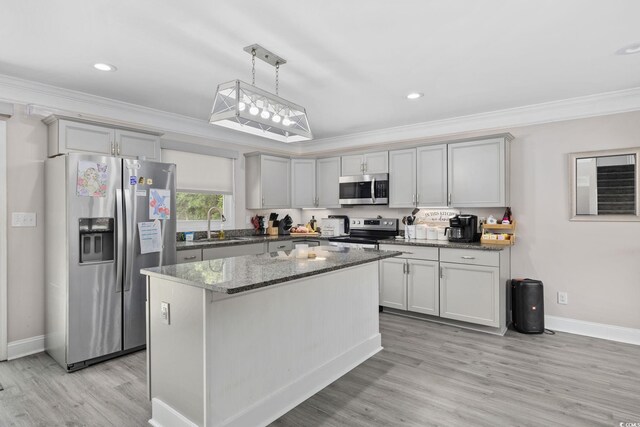 1720 Horry St, Conway, SC 29526 - kitchen with appliances with stainless steel finishes, crown molding, baseboards, dark stone counters, and light wood-style floors