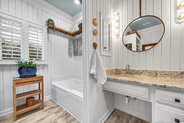 full bathroom featuring wood finished floors and vanity