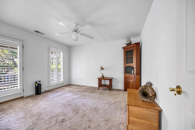 living area featuring a ceiling fan, carpet flooring, and baseboards